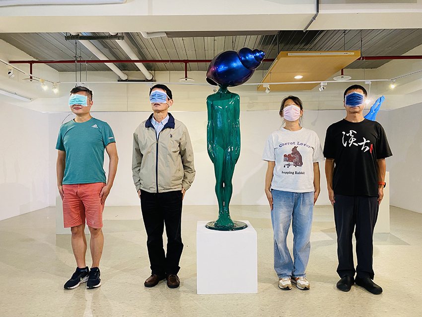 淡古駐村藝術家簡俊成（左一）與參觀民眾以口罩遮臉與作品《寂靜的心》合影，留下有趣...