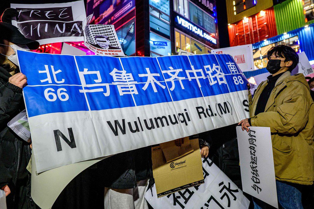 首爾抗議群眾手持「烏魯木齊中路」標語，象徵著在上海出現抗爭後被官方拆下的路牌。 ...