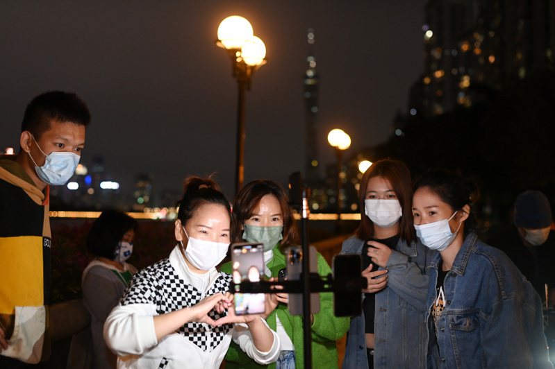 11月30日廣州多區宣佈解除疫情防控臨時管控區，疫情最嚴重的廣州市海珠區市民30日在珠江邊聊天直播。（中新社）