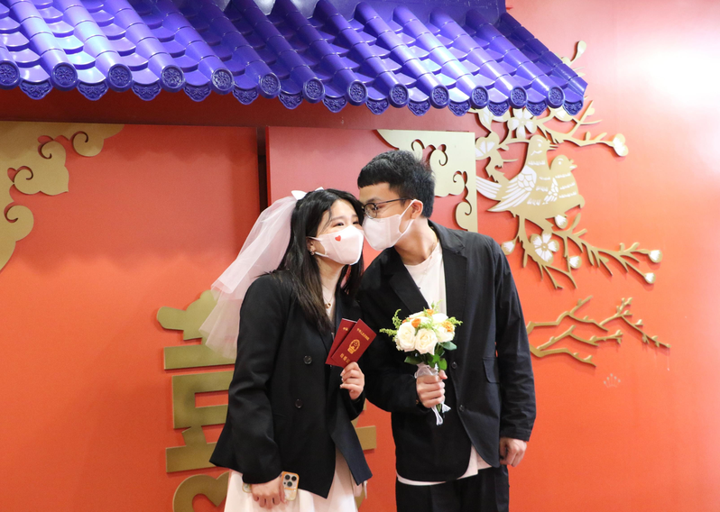 圖為今年5月20日，浙江杭州一對新人在婚姻登記處拍照留念。中新社