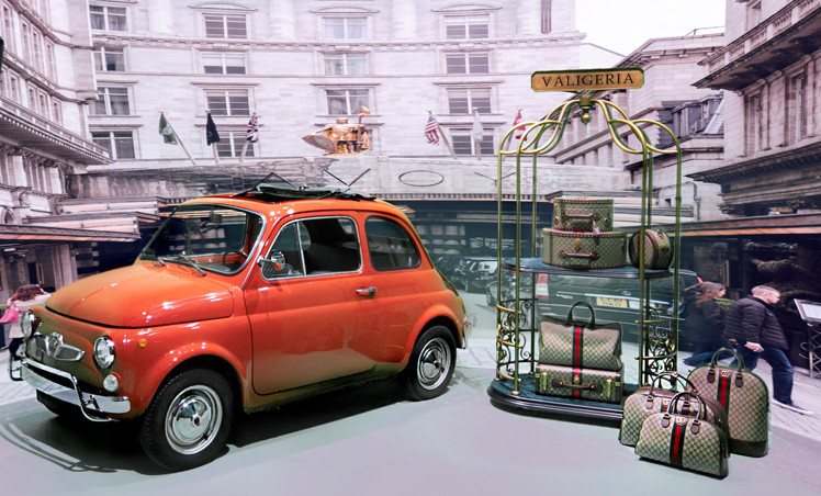 橘色的Fiat骨董小車，帶出復古、時髦、趣味的義式生活風格，更有品牌創辦人古馳先生與旅行、旅行箱的千絲萬縷。 圖 / GUCCI提供