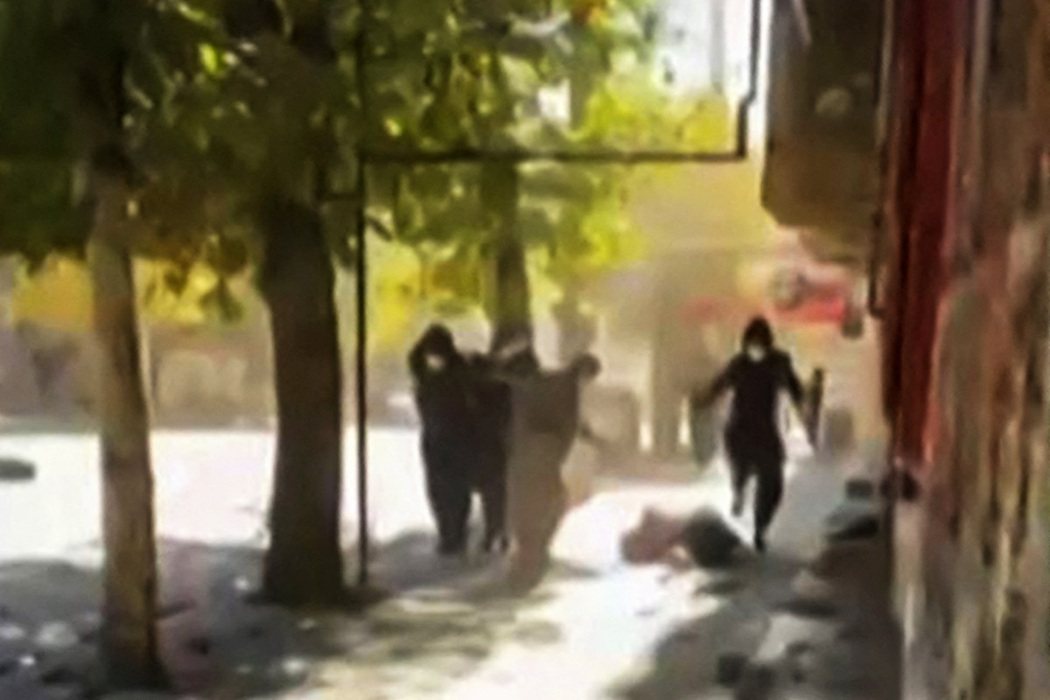 11月21日在伊朗街頭有示威民眾被警察暴打。 圖／法新社