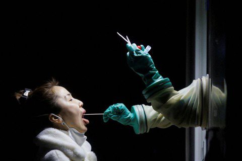 北京一名女子接受核酸檢測。 圖／路透社