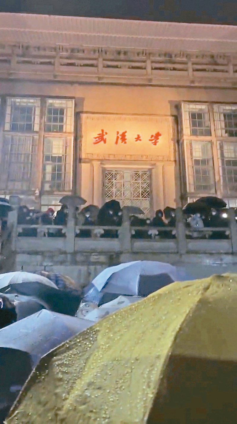 白紙運動後，大陸又出現校園抗爭，數百名武漢大學生四日晚間抗議校方防疫政策，他們聚集在行政大樓門口高喊口號。（路透）