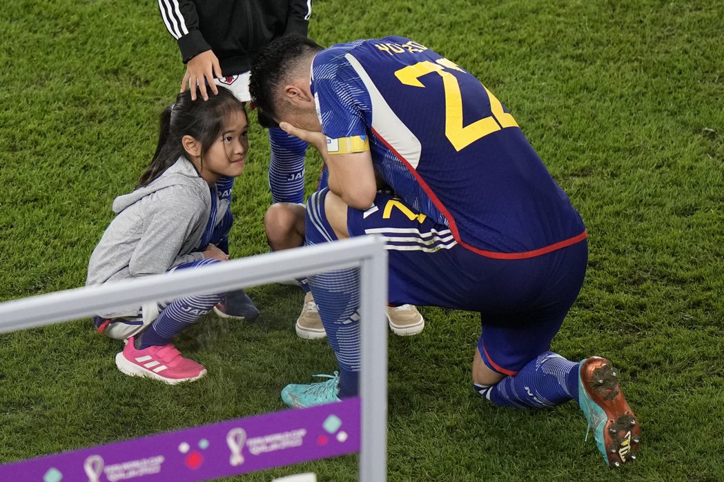 日本隊長吉田麻也在落敗後下跪痛哭，他的女兒從場邊進入安慰父親。 圖／美聯社