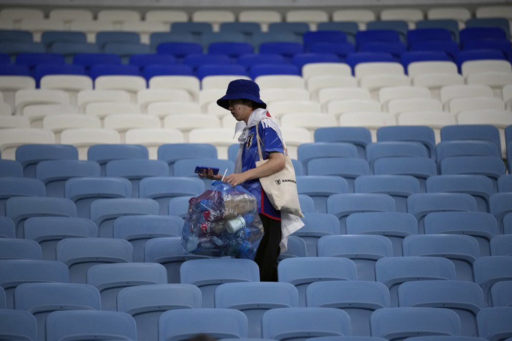 日本隊球迷在每一場比賽結束後，都用藍色垃圾袋收走觀眾席垃圾。 圖／美聯社