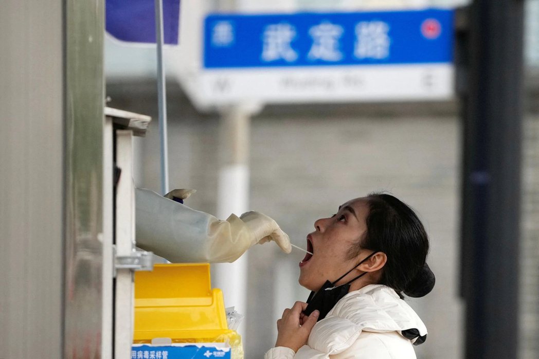 上海一名女子正在接受核酸檢測。 圖／路透社