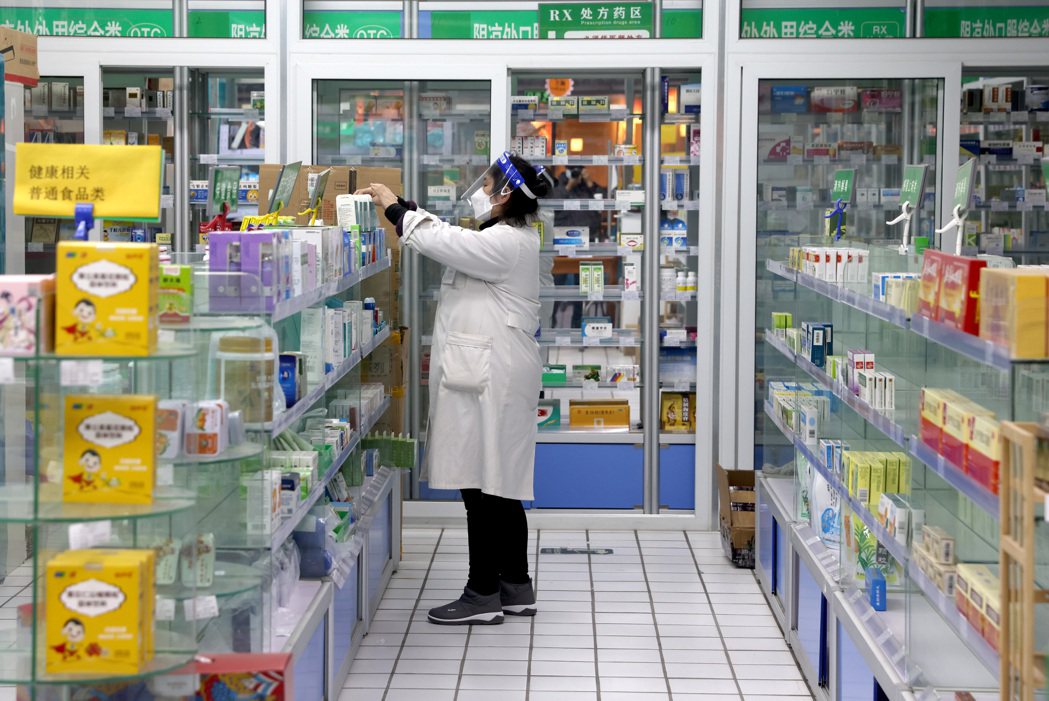 大陸允許感染者可居家隔離，民眾不再實名購買「四類」藥品，圖為北京一家藥店的工作人...
