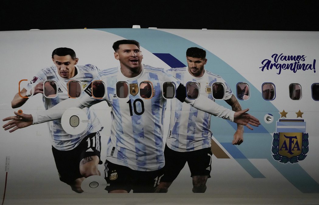 載著阿根廷國家隊抵達卡達世界盃的班機，機身上畫著（左起）迪馬利亞、梅西、德保羅的...