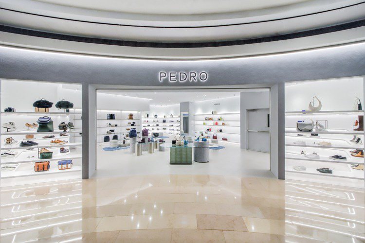 PEDRO台北101店以淺砂灰色主體搭配圓弧流線造型，呈現如藝廊般的簡潔氛圍，並點綴天空藍及湖水綠成為視覺焦點，同時帶出低調奢華的質感。圖／PEDRO提供