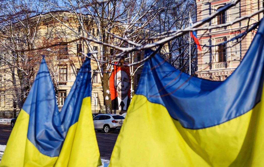 12 月 8 日，俄羅斯駐拉脫維亞大使館外的旁邊被掛上烏克蘭國旗，對面掛著普丁的...