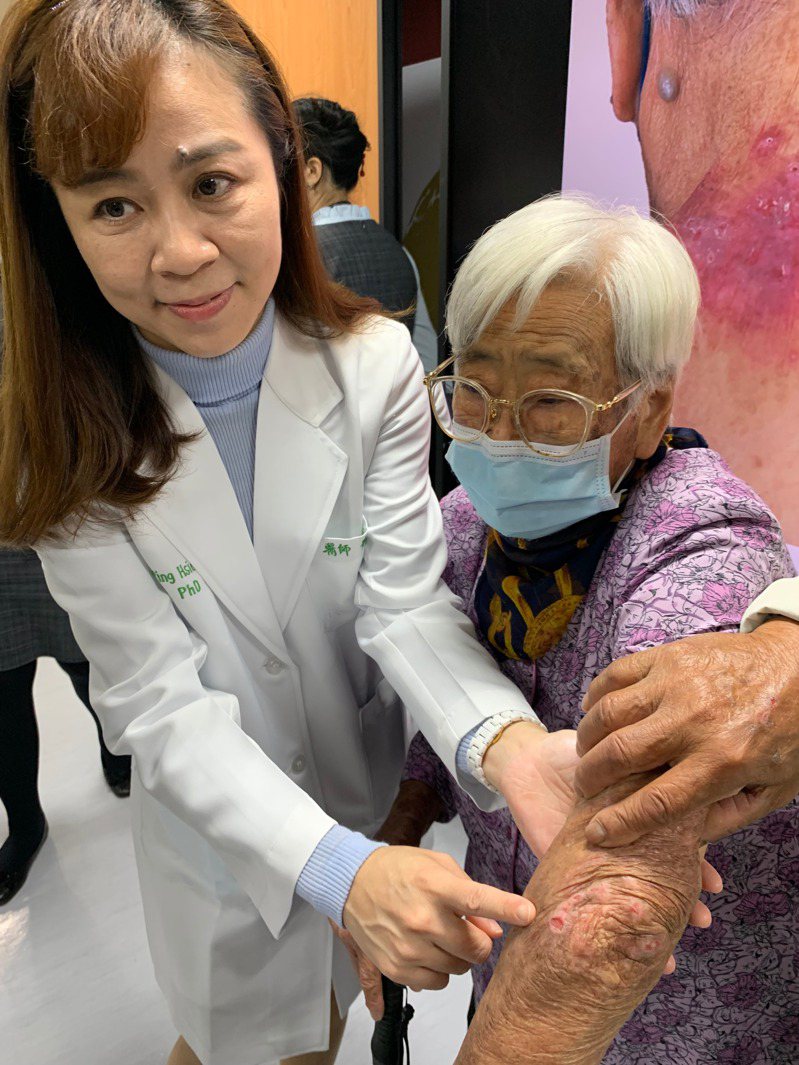 醫師蕭玉屏（左）說明，老婦人（右）經使用新型的口服標靶小分子藥物治療，明顯好轉，皮膚不癢了，結節、傷口也好了。圖／中山附醫提供