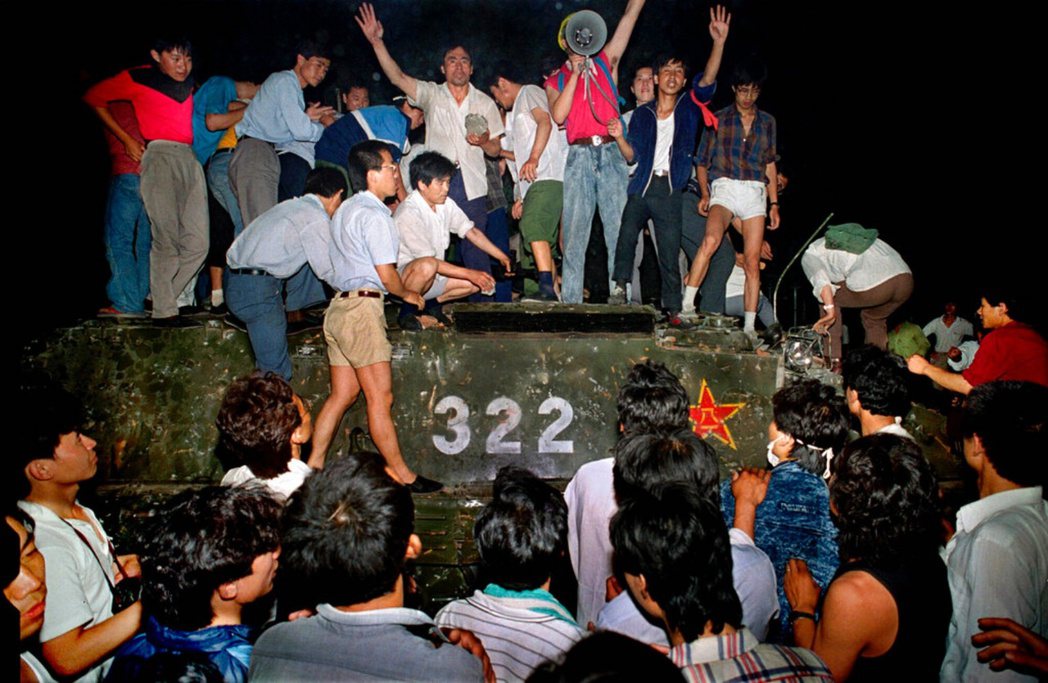 1989 年 6 月的北京，市民們拿著石頭站在軍用裝甲車上。 圖／美聯社 