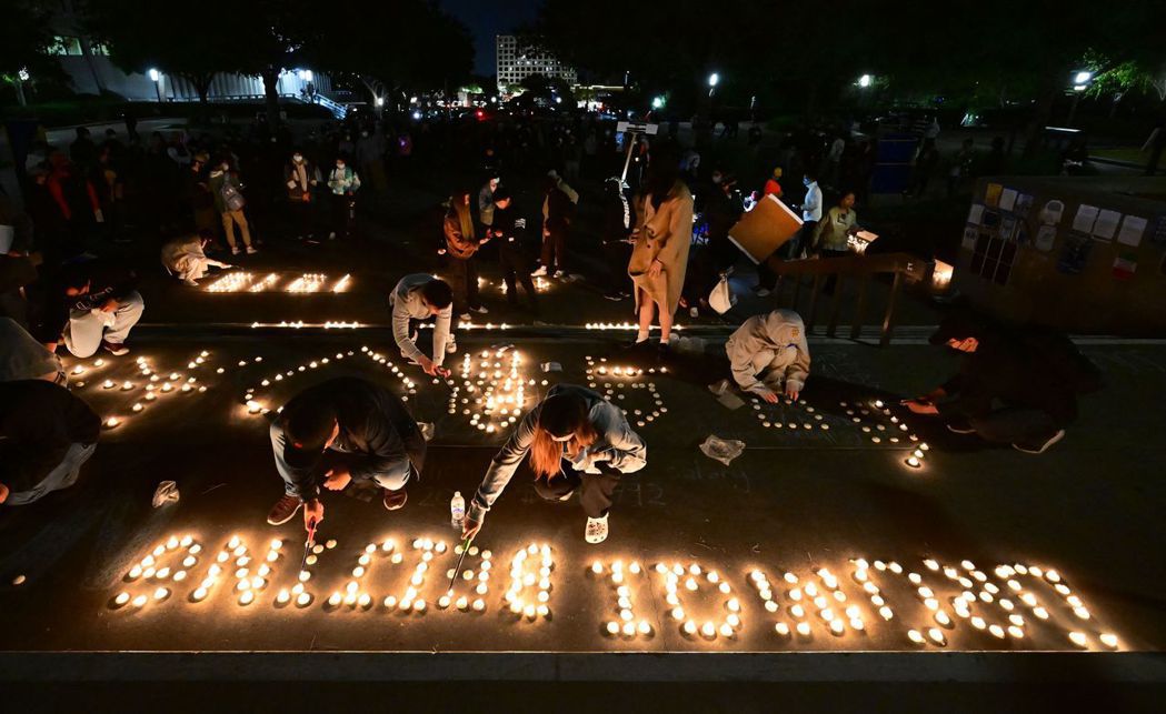 圖為在加州大學爾灣分校的白紙革命集會，海外中國人以蠟燭排出英文的「烏魯木齊」、「...