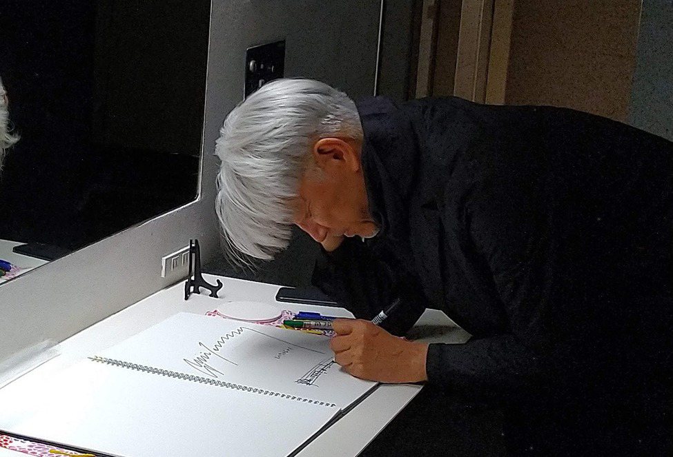 坂本龍一留下簽名，他彎腰，畫起五線譜，上面音符飛揚。 圖／藍祖蔚提供