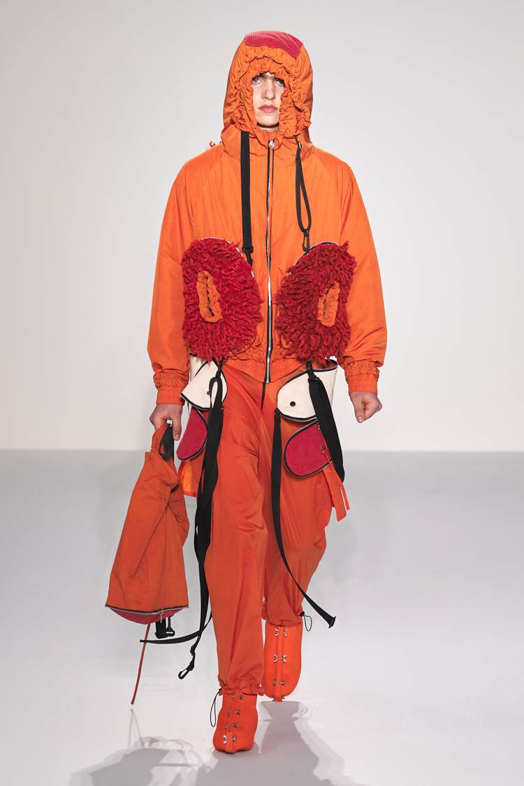 Craig Green秋冬主打款，以醒目的橘色軍裝外套搭配豐富配件，營造出不羈的...
