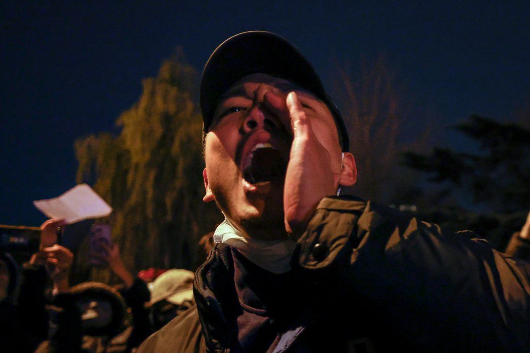 11月26日中國南京傳媒學院一名女學生手舉白紙，弔念因新疆烏魯木齊政府過度防疫而死於大樓火災的遇難者，開啟了中國多地，人民向政府表達不滿防疫政策的「白紙運動」。圖為11月27日北京抗議群眾。 圖／歐新社