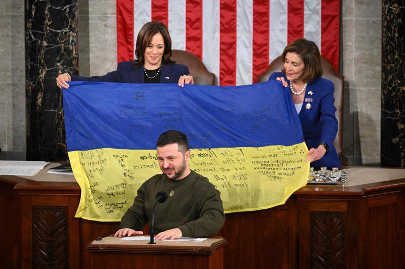 烏克蘭總統澤倫斯基（中）21日在美國國會兩院聯席會議中發表演說。後方為聯邦參議院議長兼副總統賀錦麗和聯邦眾議院議長裴洛西，兩人拿著澤倫斯基致贈的烏克蘭國旗。法新社