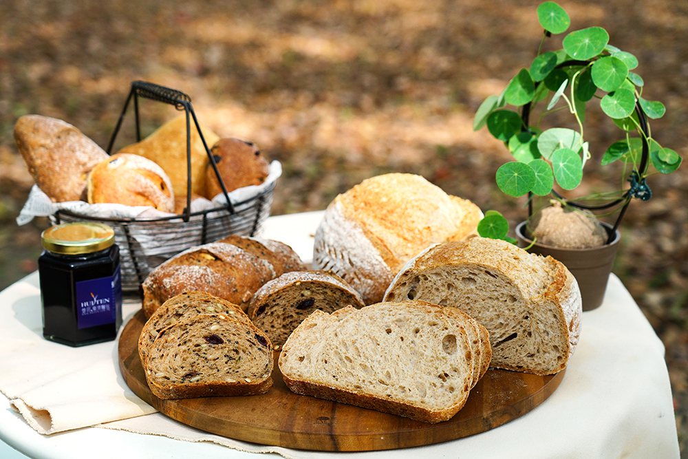 切開慧田的歐式麵包，不規則孔隙是使用天然酵母的證明，麵包的甜味並非來自糖，而是咀...