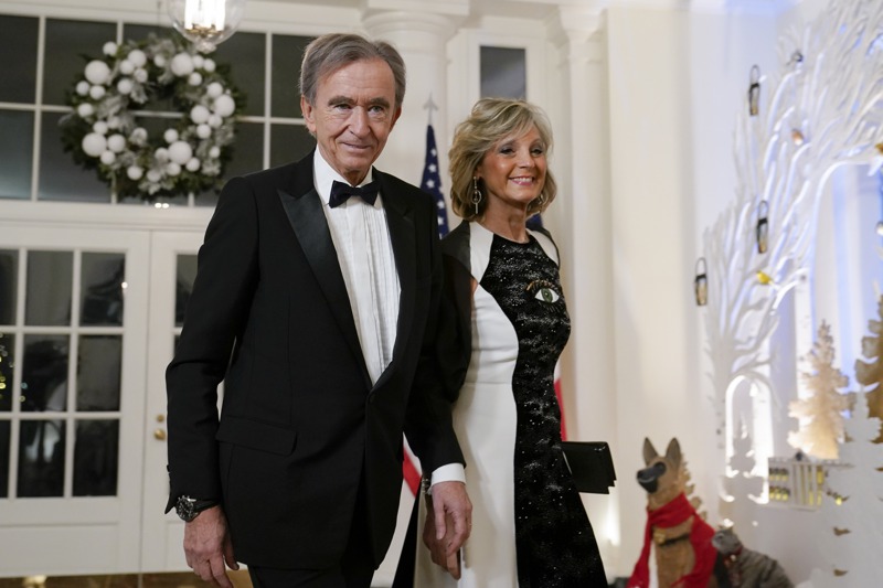 法國LVMH集團老闆阿爾諾（左）日前取代馬斯克成為全球首富。圖為阿爾諾12月1日偕第二任妻子穆瑟（右）出席白宮款待法國總統馬克宏的國宴。美聯社