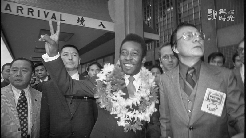 舉世聞名的巴西球王「黑珍珠」比利、於下午由美國搭機飛台北機場後，舉起象徵勝利的「V」字形手勢，向歡迎他的中國球迷致意。圖／聯合報系資料照（ 1977/02/05　程川康攝影）