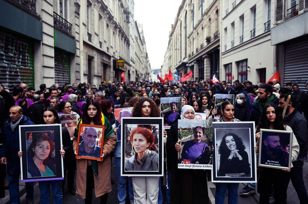 12月26日，示威者在巴黎舉著槍殺案受害者的肖像，聲援庫德族。 圖／法新社 