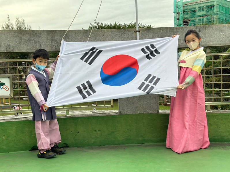 東華附小有22名外籍學生來自10個不同國家，今天舉辦國際聯合升旗典禮，升起韓國等12面不同國家的國旗。圖／東華附小提供