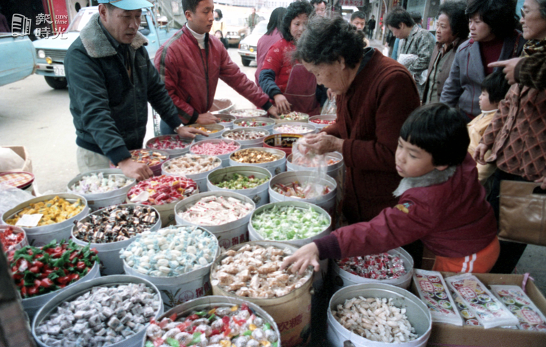 農曆年將近，迪化街趕辦年貨的人潮未曾斷過。圖中民眾購選購糖果的情況。圖／聯合報系資料照（1984/01/30　楊士正攝影）

