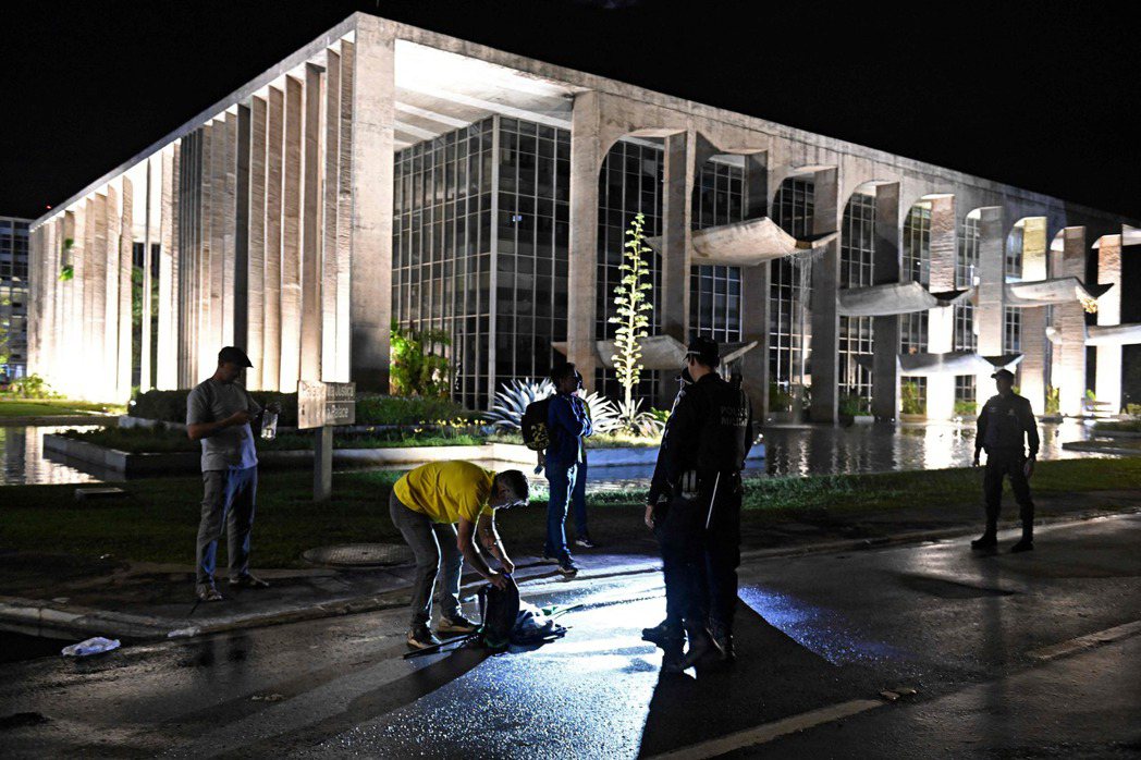 入夜後，巴西安全警察在法院外搜查博索納羅的支持者。 圖／法新社