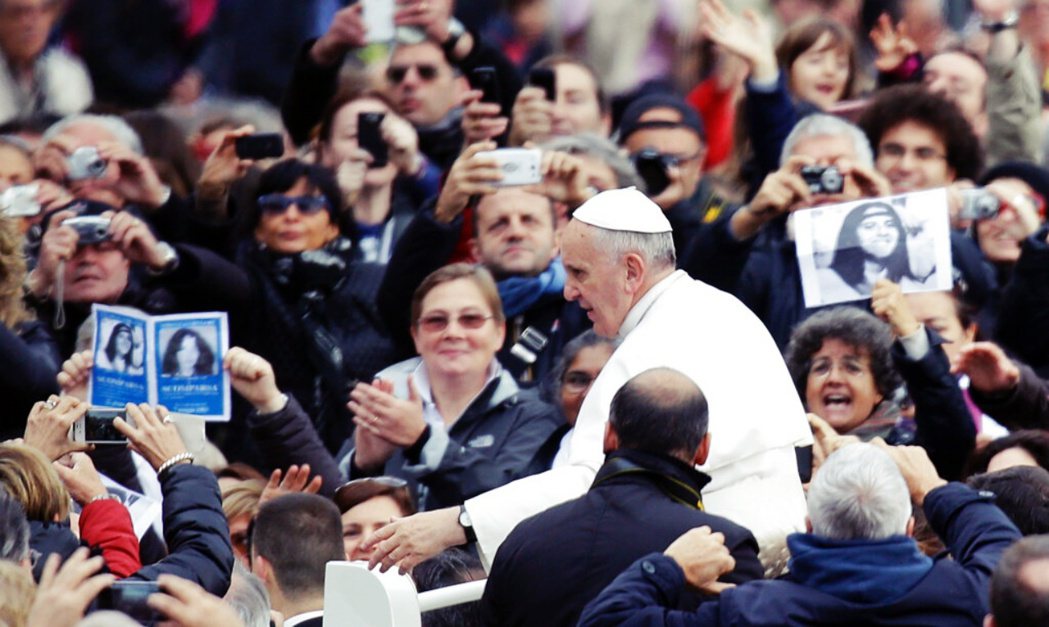 2013年，當教宗在梵蒂岡聖彼得廣場出席活動時，有民眾舉著奧蘭迪的照片。 圖／美...