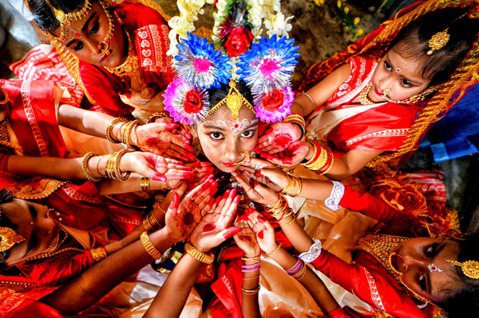 一名打扮成印度教女神杜爾迦（Durga）的女孩，被同伴圍繞。 圖／美聯社　