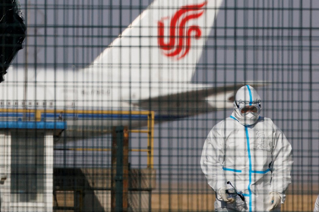 2023年1月6日，一名身穿防護服的「大白」在北京首都國際機場的一架中國國航航空...