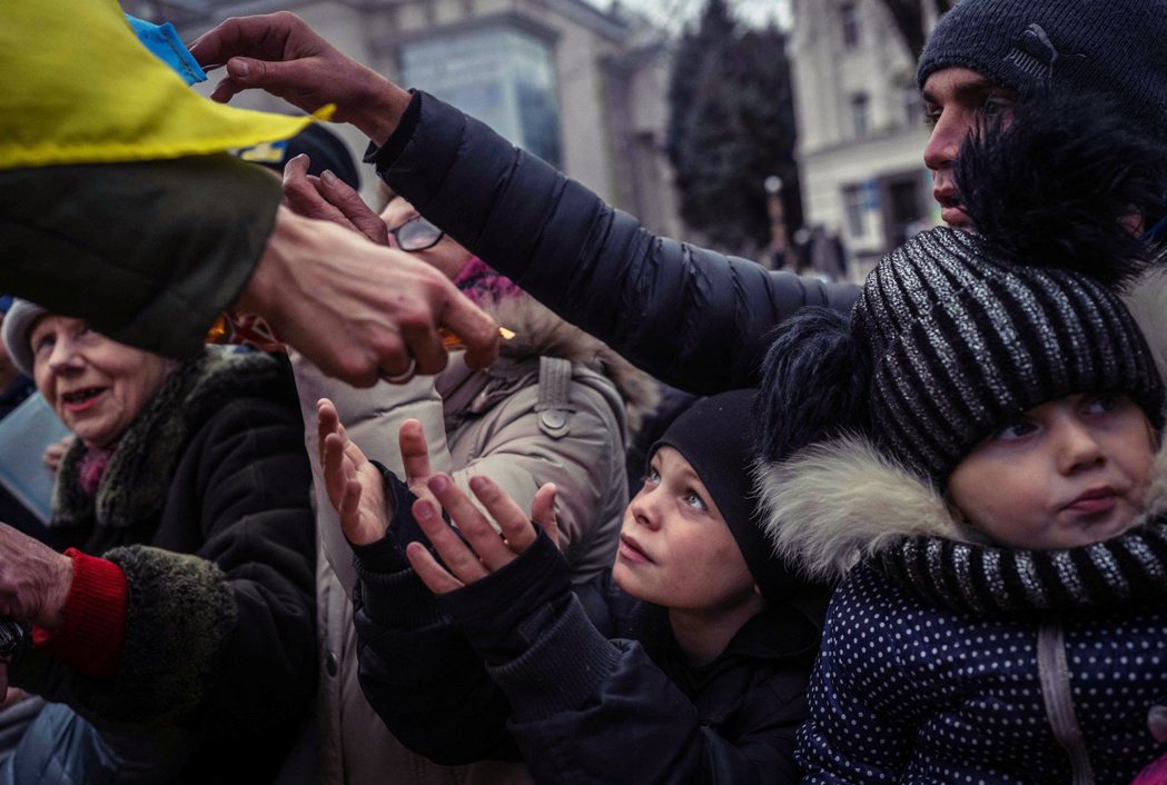 圖為在烏克蘭南部城市赫爾松領取援助物資的小孩。 圖／法新社