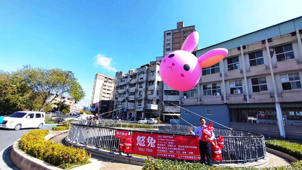 台中市豐原國小旁水岸花都河岸公園飄著一隻5米高的粉紅色「悠兔」氣球，藍天白雲襯托...