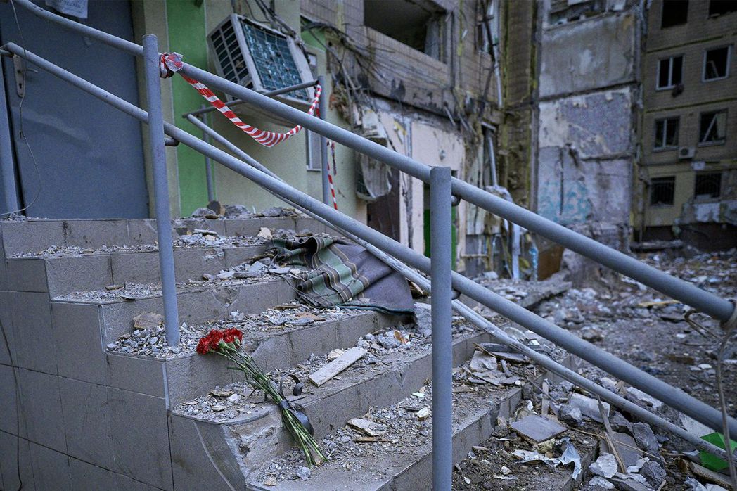 烏克蘭民眾在被炸毀的第聶伯羅公寓外獻花哀悼。 圖／法新社