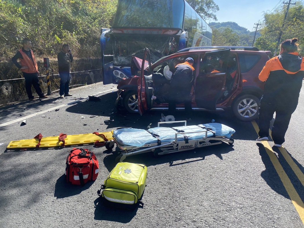 高市美濃區小客車撞遊覽車，消防救護員破獲小客車的變形車體，搶救傷者。圖／讀者提供