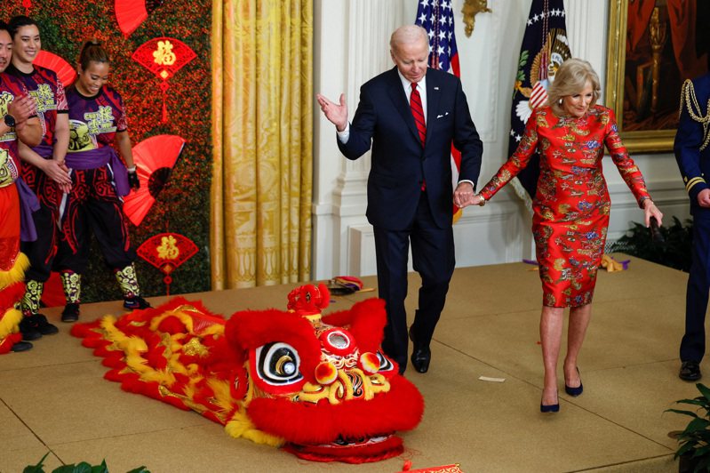 新年大紅袍 討個好彩頭 美國總統拜登與夫人吉兒廿六日在白宮主持慶祝農曆新年儀式，拜登繫上紅領帶，吉兒更換上紅色旗袍，牆上還貼著福字，滿室喜氣洋洋。（路透）