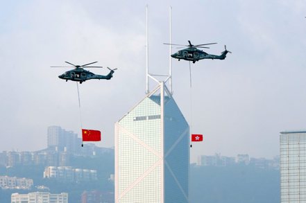 近年香港占國銀整體海外市場獲利比重明顯下降，但不少銀行卻說香港市場重要，暫難被新加坡等金融中心取代。圖為大陸解放軍直升機飛越香港中銀大廈。 中新社