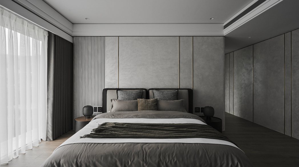 私區臥室延續整體的靜謐基調，以深色系塑 造沈穩舒心的休憩氛圍。
