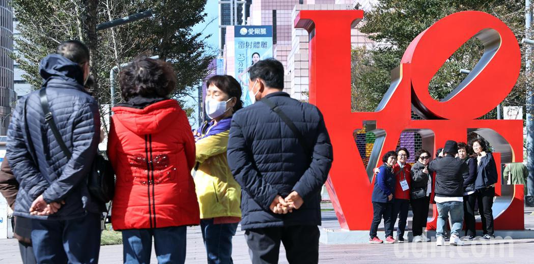 在舒適宜人的溫暖冬陽下，韓國觀光客在101大樓前閒聊或拍照留念。記者侯永全／攝影