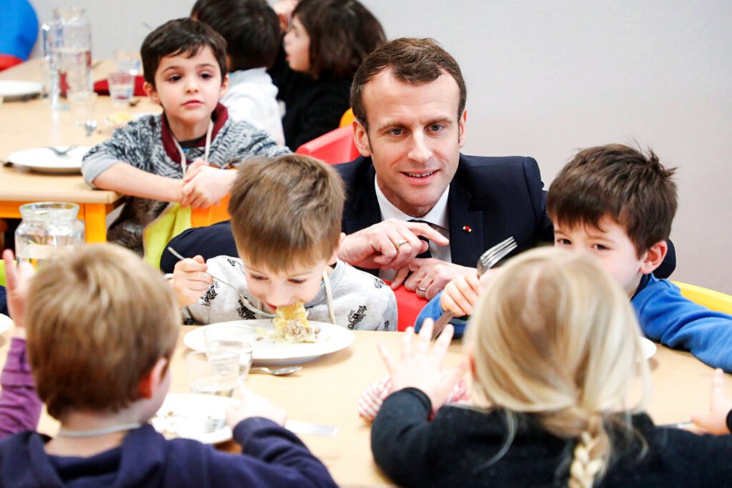 法國總統馬克宏於聖索齊的小學與學童共進午餐。 圖／美聯社    