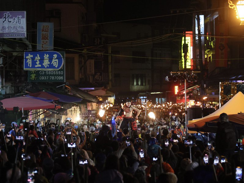 北埔老街擠滿參與油笐火夜遊的民眾，現場還有火舞表演，吸引遊客紛紛拿起手機紀錄。圖／北埔鄉公所提供