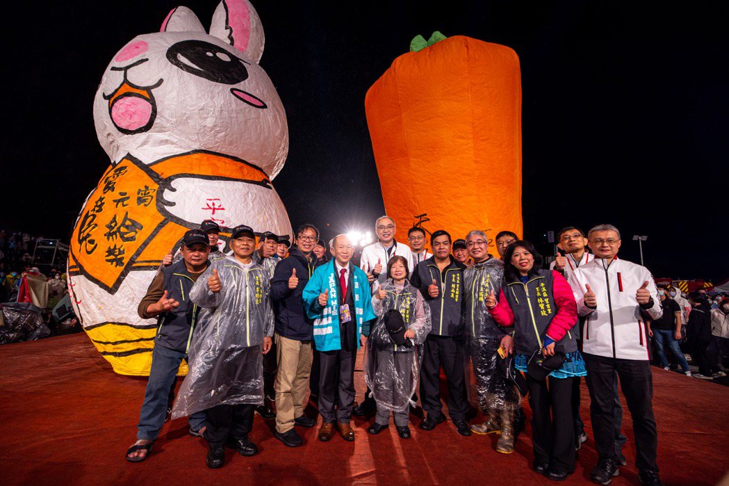 新北市副市長謝政達在主燈上寫下「平安幸福兔U」，並與來賓共同施放兔年雙主燈。圖／...