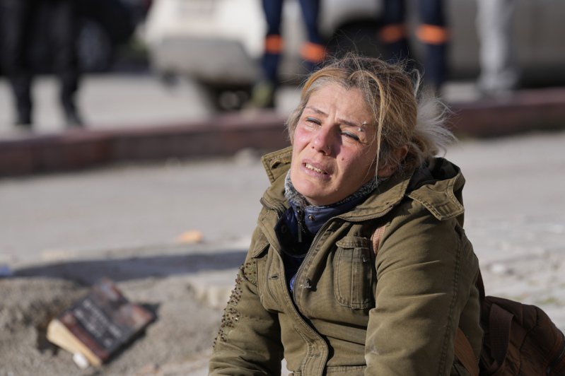 受到地震影響、家園倒塌的土耳其居民坐在廢墟之中。    (美聯社)