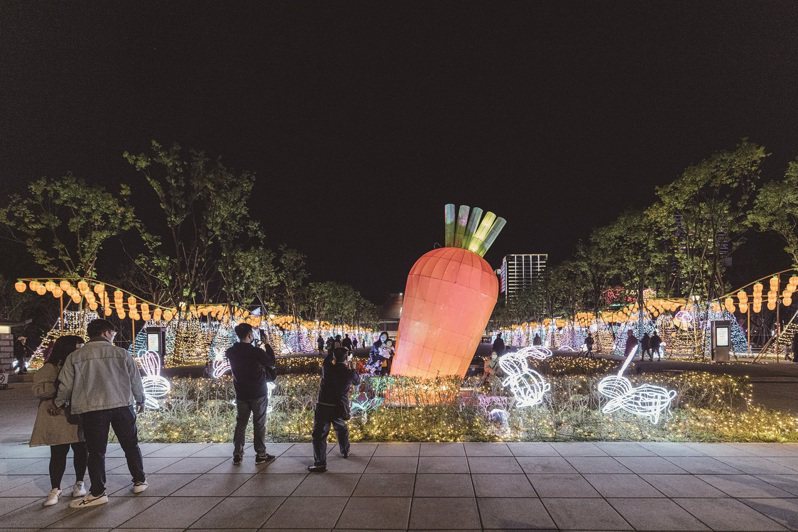 巨大的紅蘿蔔造型花燈，不只吸引可愛的白兔圍繞，也吸引民眾上前拍照，為中央展區增添活潑、趣味的氛圍。 （攝影／林冠良）