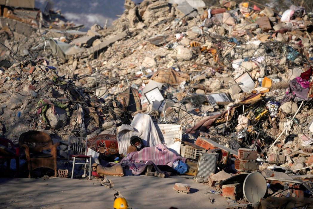 在卡赫拉曼馬拉什倒塌房屋旁的災民。 圖／美聯社    