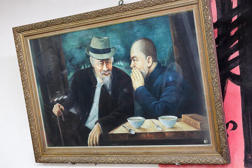 在老闆鍾文科經常坐的位置上方，掛著一幅懷念父親鍾阿里（右）與大伯（左）的畫像。 ...