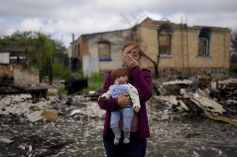 烏俄戰爭持續一年，戰火仍不見盡頭。圖為基輔近郊，一名婦人從被俄軍炸毀的房子內找到...