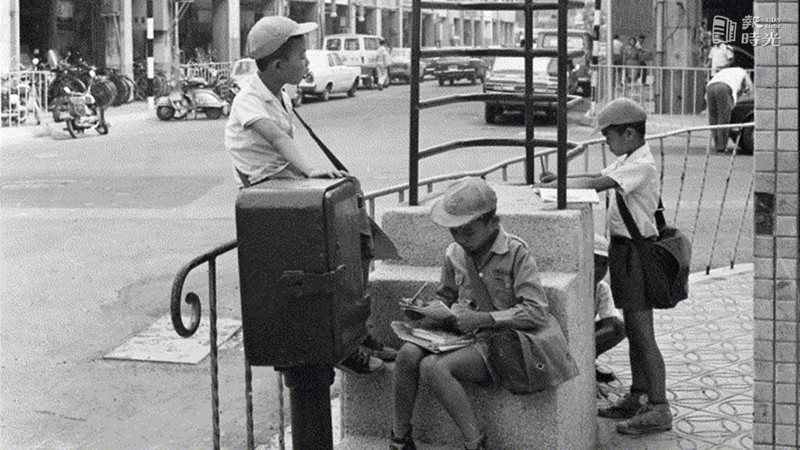 街景，學童在路旁讀書。圖／聯合報系資料照（1972/06/08　高鍵助攝影） 
