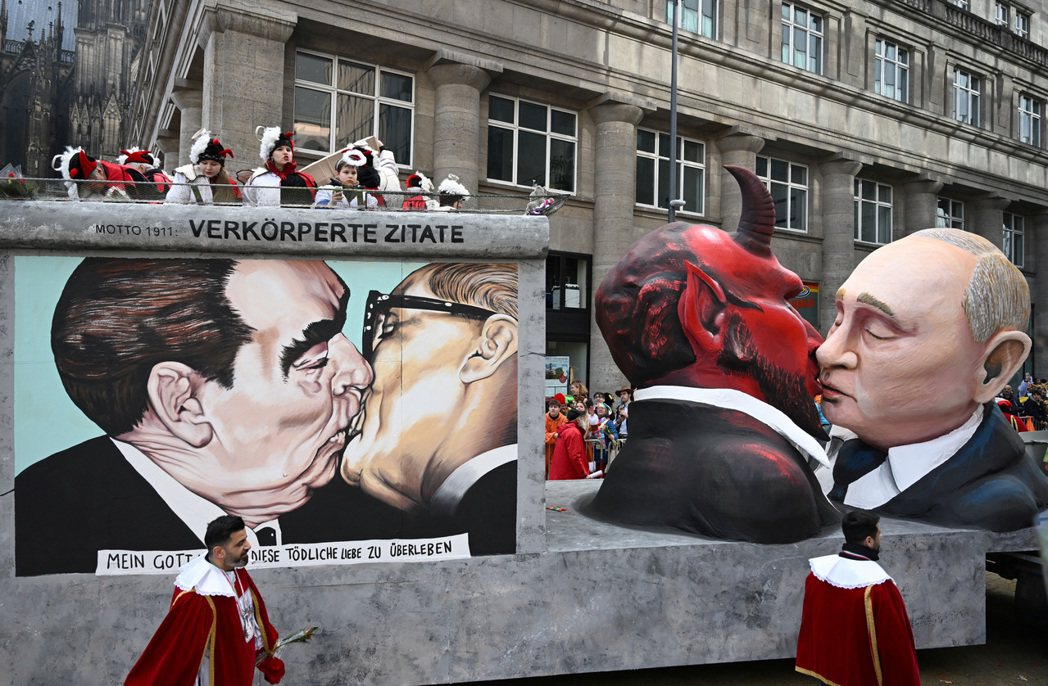 德國科隆嘉年華遊行花車上，以柏林圍牆名畫「兄弟之吻」（左）諷刺普丁的裝置藝術。 ...